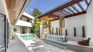 A modern outdoor patio with a pool, a seating area, and a variety of plants. - Villa Harper by BaliSuperHost (Bali)