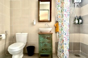 A bathroom with a toilet, sink, and shower curtain. - 3BR KL Sentral L21 Modern Vintage City View (Kuala Lumpur)