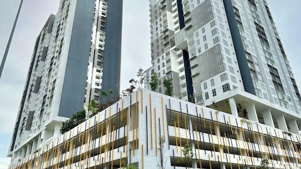 Un edificio residencial alto con múltiples balcones y un diseño arquitectónico moderno.