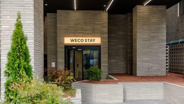 Um edifício moderno com uma placa que diz 'WECO STAY'.