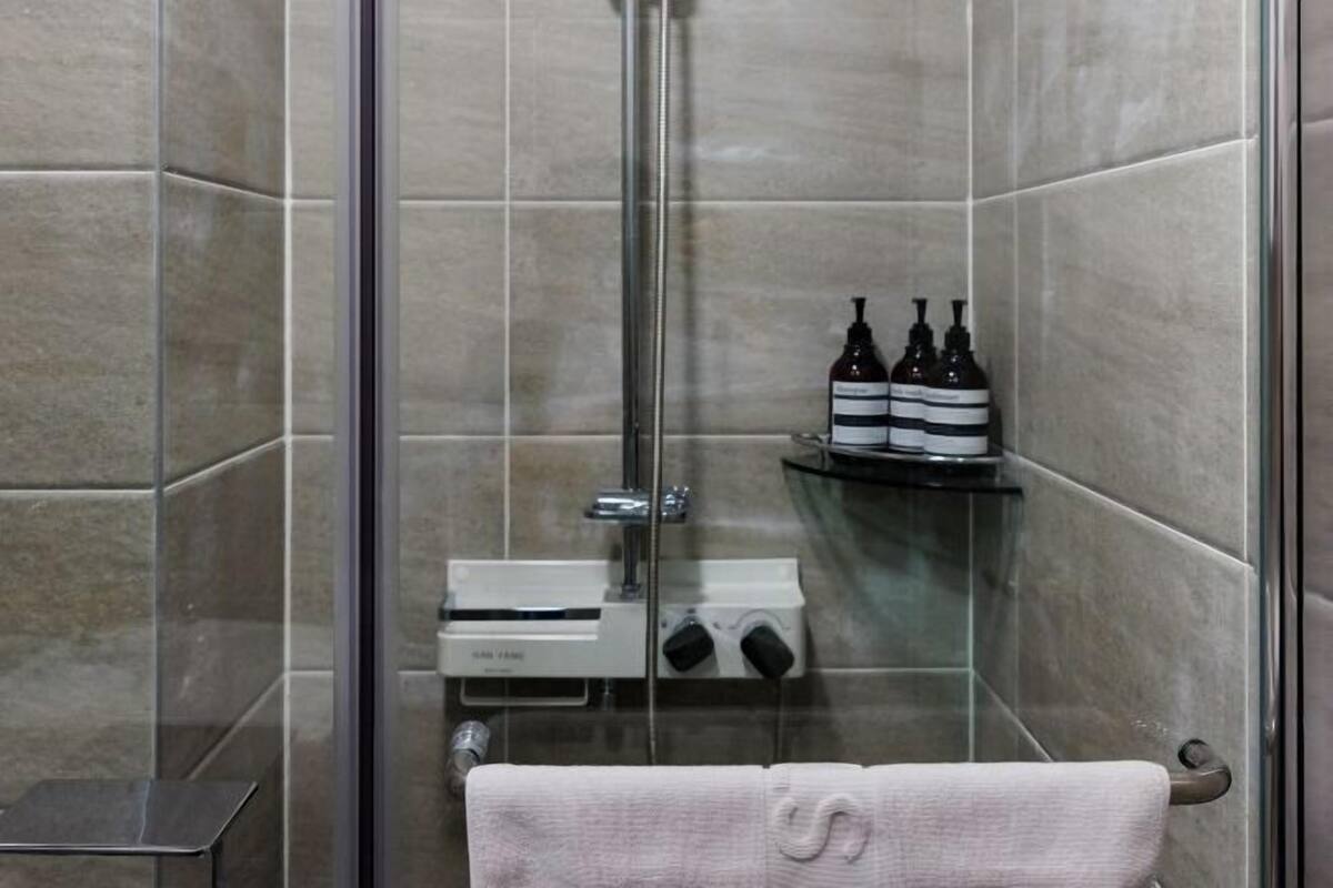 Eine Duschkabine mit Handtuchhalter und Ablage für Toilettenartikel.
