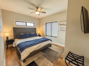 A bedroom with a bed, nightstands, a ceiling fan, and two windows with blinds. - NEW Construction! Free Community Golf and More (Swanton)
