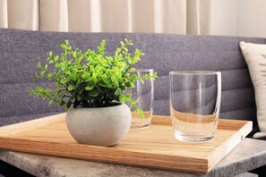 A potted plant on a wooden tray on a marble table, with two glasses of water. - Tokyo Asakusa House (Tokyo)