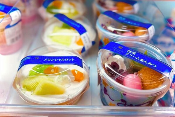 Vitrine refrigerada com diversos doces embalados.