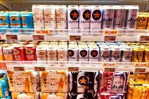 A shelf stocked with various canned beverages, including brands like Sapporo and Asahi. - Tokyo Asakusa House (Tokyo)