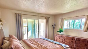 A bedroom with a large bed, a dresser, a nightstand, a window with curtains, and a ceiling fan. - 
Your Borrego Bungalow: 2BR/2BA at Roadrunner Golf and C.C. Golf cart included! (Borrego Springs)