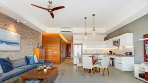 Un salon moderne comprenant un canapé, une table basse et un coin repas avec des chaises et une table.