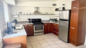 A modern kitchen with stainless steel appliances, wooden cabinets, and a tiled floor. - Bright and Cozy Tucson Condo - Ideal for families, couples and friends (Tucson)