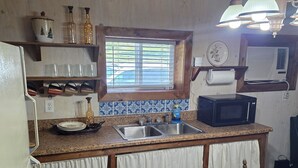 A kitchen with a wooden countertop, a sink, a microwave, and a window with blinds. - Rowdy Ridge Yee Yee (Northfork)