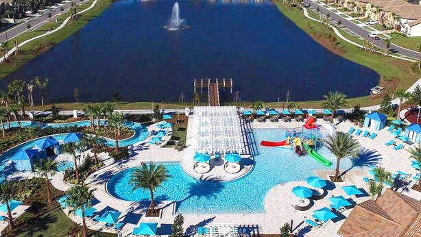 Un complexe hôtelier doté d’une grande piscine centrale, d’un toboggan aquatique et de plusieurs piscines plus petites.