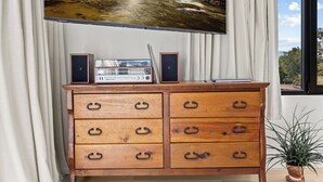 Une commode en bois avec des tiroirs, et un téléviseur à écran plat fixé au-dessus.