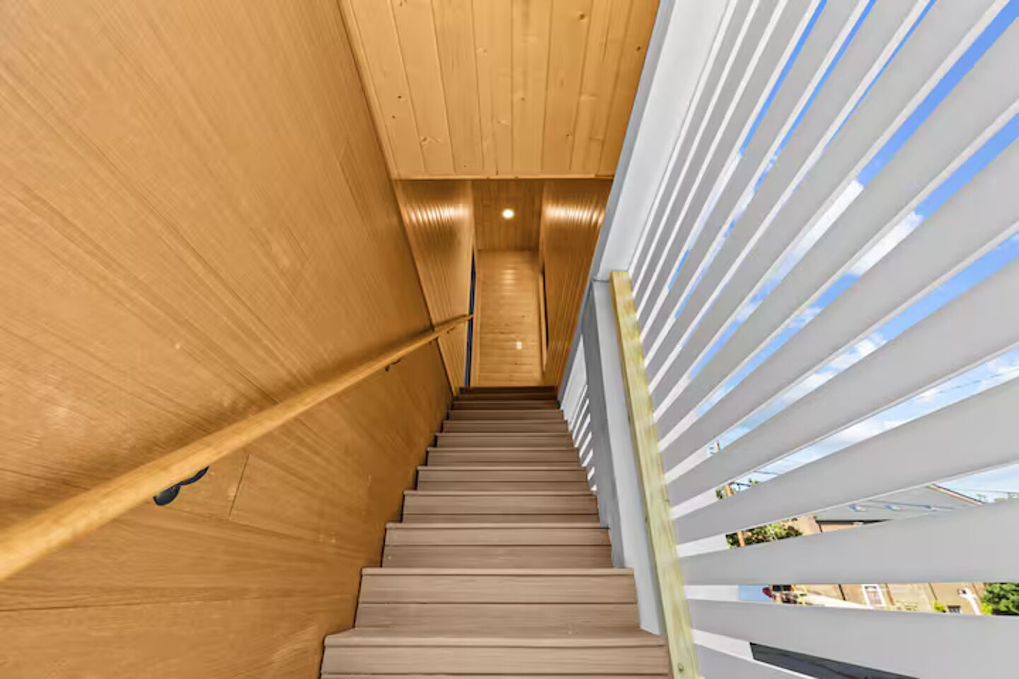 Un escalier en bois, doté d’une rampe, qui mène à un niveau supérieur.