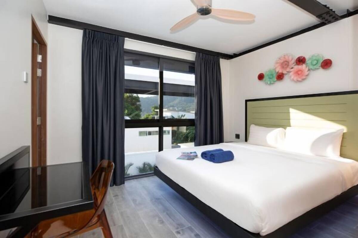 A hotel room with a bed, a desk, and a chair.