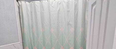 Une salle de bain avec des toilettes, un rideau de douche et un lavabo.