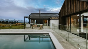 A modern house with a swimming pool, large windows, and a view of mountains. - Riverslea - Pool - Sleeps 10 (Wānaka)