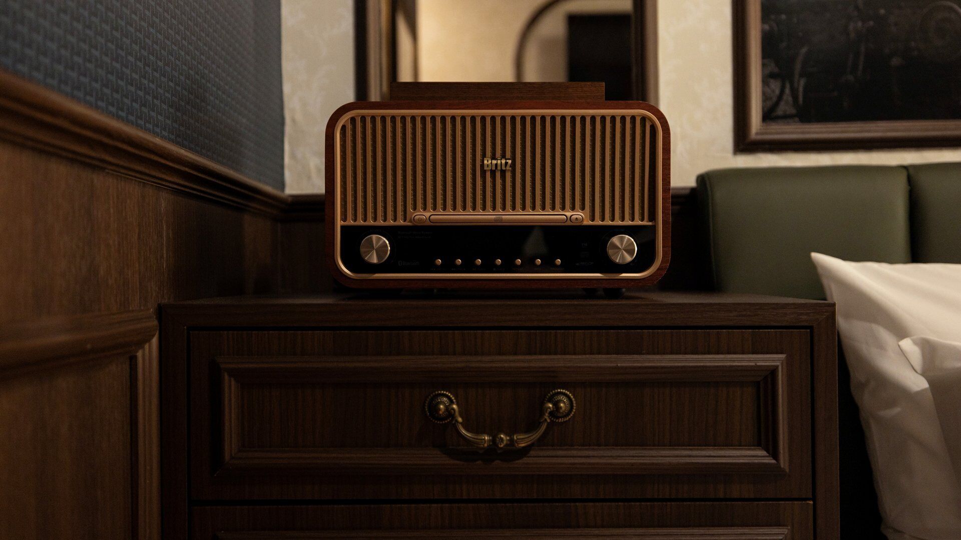 Ein Nachttisch aus Holz mit Radio und Schublade.