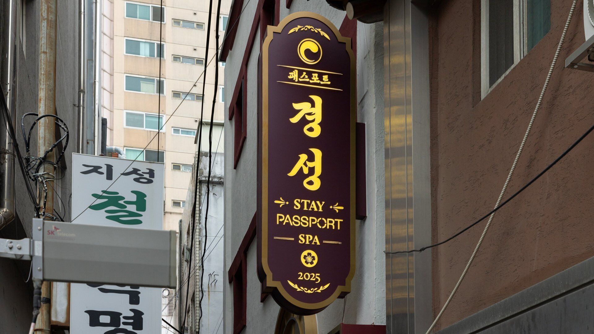 A hotel sign with Korean text and a 'Stay Passport Spa' logo, indicating a spa facility.