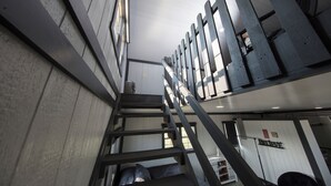 A staircase with a metal railing leading to a higher floor.