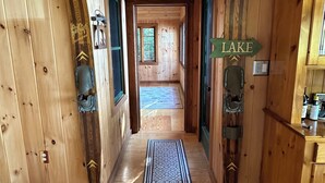 A wooden hallway with a rug leading to a room labeled "LAKE".