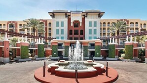 A hotel with a central fountain, multiple balconies, and a symmetrical facade with greenery. - 3BR ~ Beachfront ~ Huge Balcony ~ 2 Pools ~ Luxury (Fort Walton Beach)