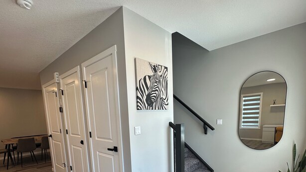 A modern interior with a staircase, a zebra artwork, and a mirror. - ✨your home away from home✨Modern
Comfort in a spacious 3-Bedroom Townhome (Airdrie)