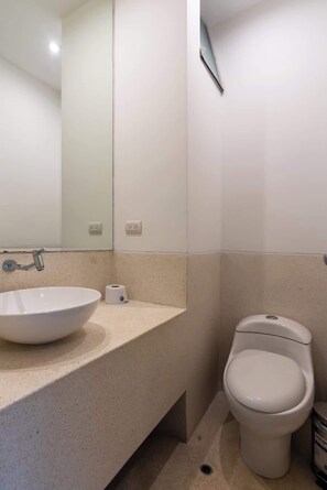 Ein Badezimmer mit Waschbecken, Toilette und Spiegel.