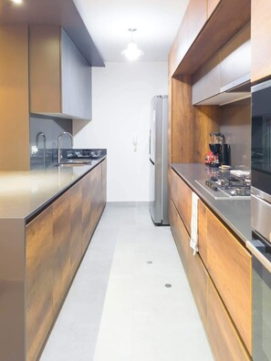 Eine moderne Küche mit einem Edelstahlkühlschrank, einer Kaffeemaschine und einem Spülbecken.