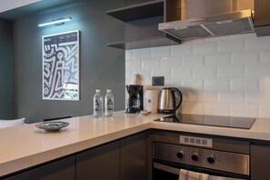 Une cuisine moderne avec un dosseret de carrelage blanc, des appareils en acier inoxydable et un design minimaliste.