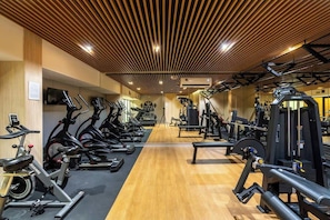 Un gimnasio con bicicletas estáticas, cintas de correr y máquinas de pesas.