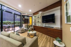 Una sala de estar moderna con un sofá, una mesa de centro y un televisor.