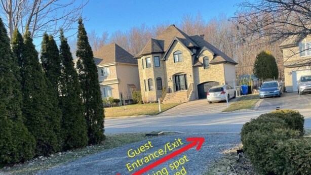 A residential driveway with a guest entrance/exit sign and a reserved parking spot. - Private apartment(bedroom, living, kitchen, bath) (Pincourt)