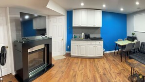 A compact living space with a kitchenette, a sofa, a chair, and a refrigerator. - Private apartment(bedroom, living, kitchen, bath) (Pincourt)