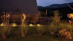 Um edifício moderno com telhado plano e um jardim bem cuidado, com grama e plantas.