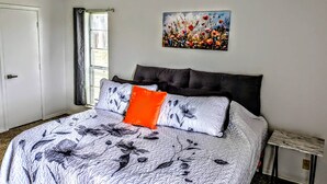 A bedroom with a bed, a painting, a window, and a door. - Game Day Getaway 1 | Walk to OSU | Prime Location (STILLWATER)