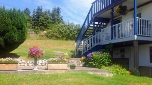 A two-story building with a blue balcony and white railings. - The Founder's Vista Suite Spacious, Panoramic Ocean Views (Alert Bay)