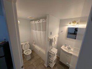 A bathroom with a toilet, bathtub, and sink. - The Sitka Suite | Central Apartment, Waterfront, 2 Beds (Alert Bay)