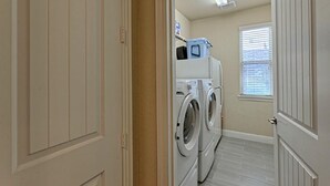 A laundry room with two front-loading washing machines and a dryer. - Spacious 5-bedroom Modern Stay Near - IAH-AIRPORT (Humble)