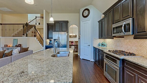 A spacious kitchen with granite countertops, stainless steel appliances, and dark wooden cabinets. - Spacious 5-bedroom Modern Stay Near - IAH-AIRPORT (Humble)