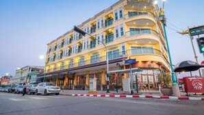 Et hotel med flere etager, en gul facade, altaner og et skilt med teksten "Landmark Hotel".