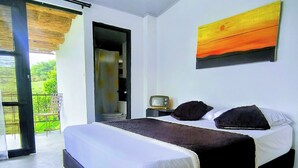 Une chambre à coucher avec un lit, une télévision et un tableau.