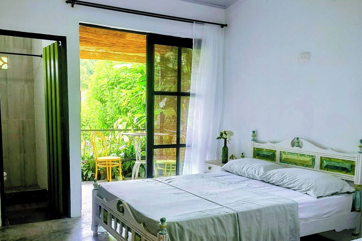 A bedroom with two beds, a cowhide rug, and a view of greenery outside.