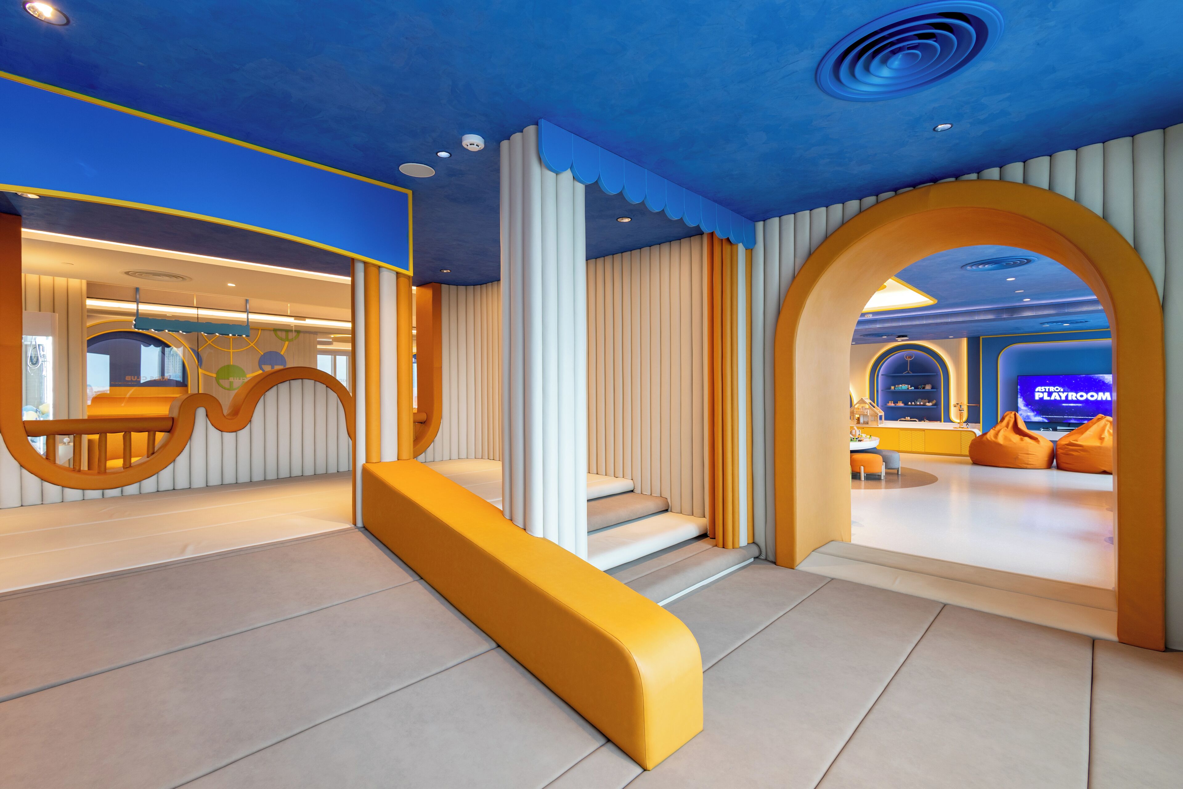 Un interior moderno con una escalera, una sala de juegos y una zona de recepción.