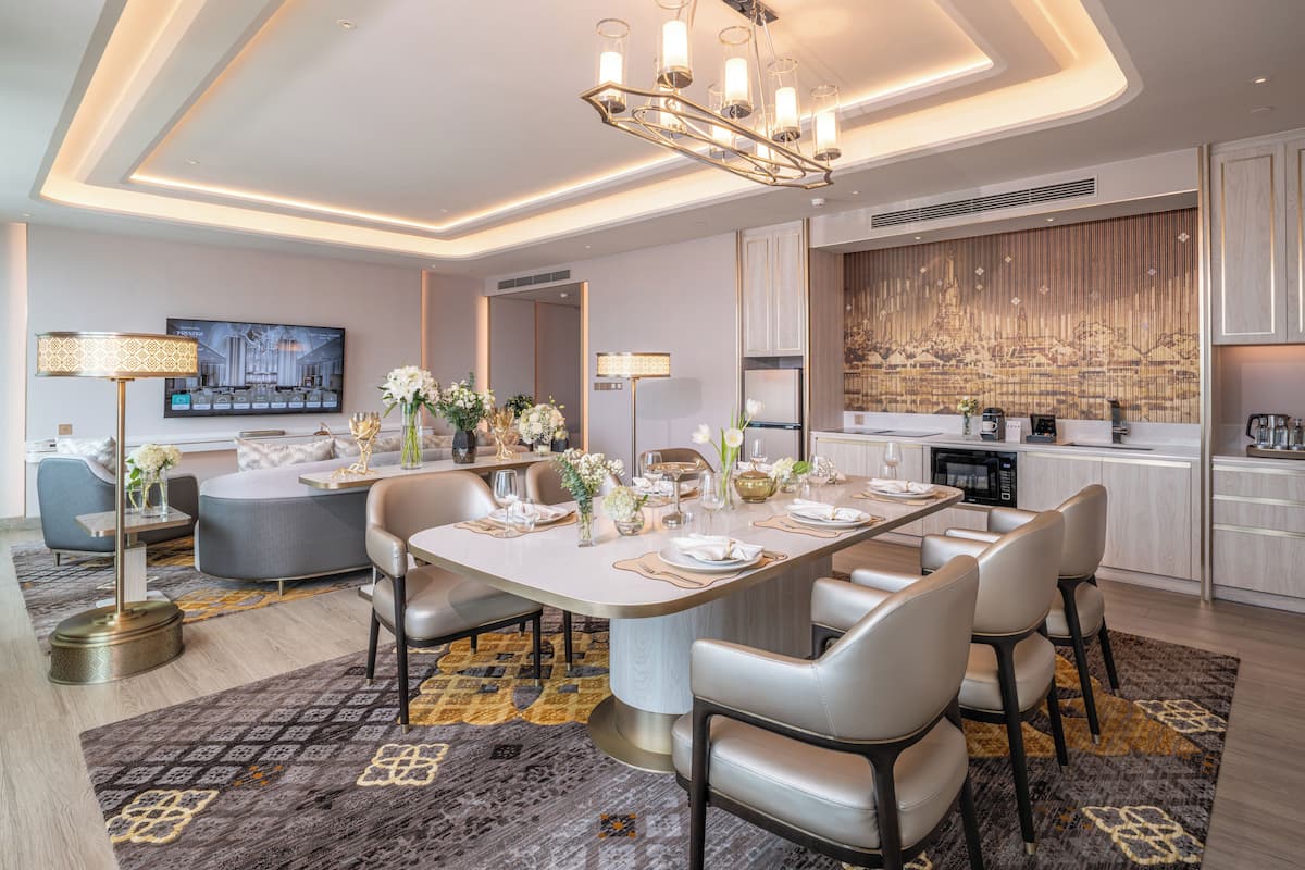 A modern dining area with a large oval table, comfortable seating, and a decorative wall with a cityscape mural.