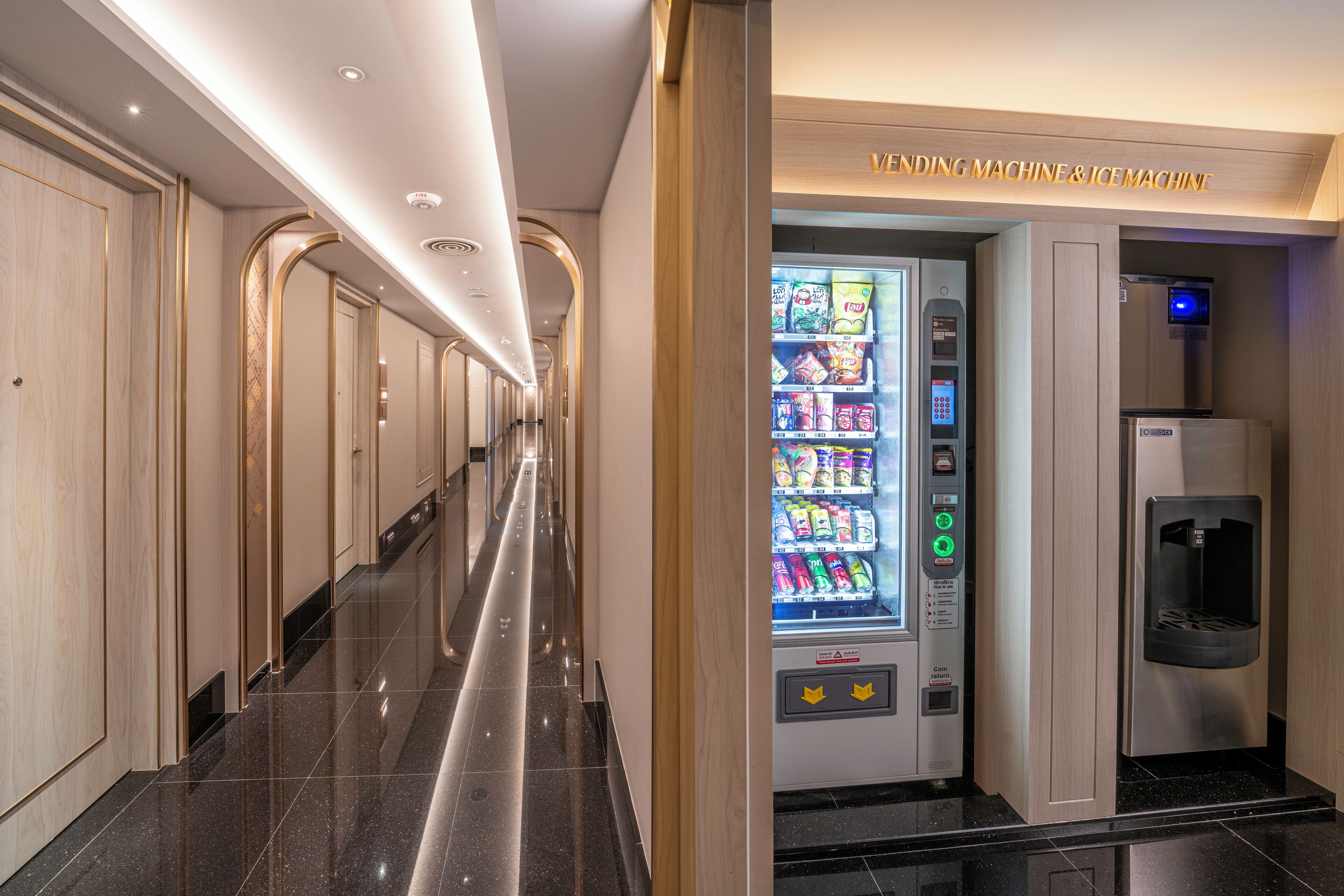 Een hotelgang met een automaat en ijsmachine.