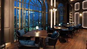 Un ristorante con vista sulla città, con tavoli e sedie disposti per consumare un pasto.