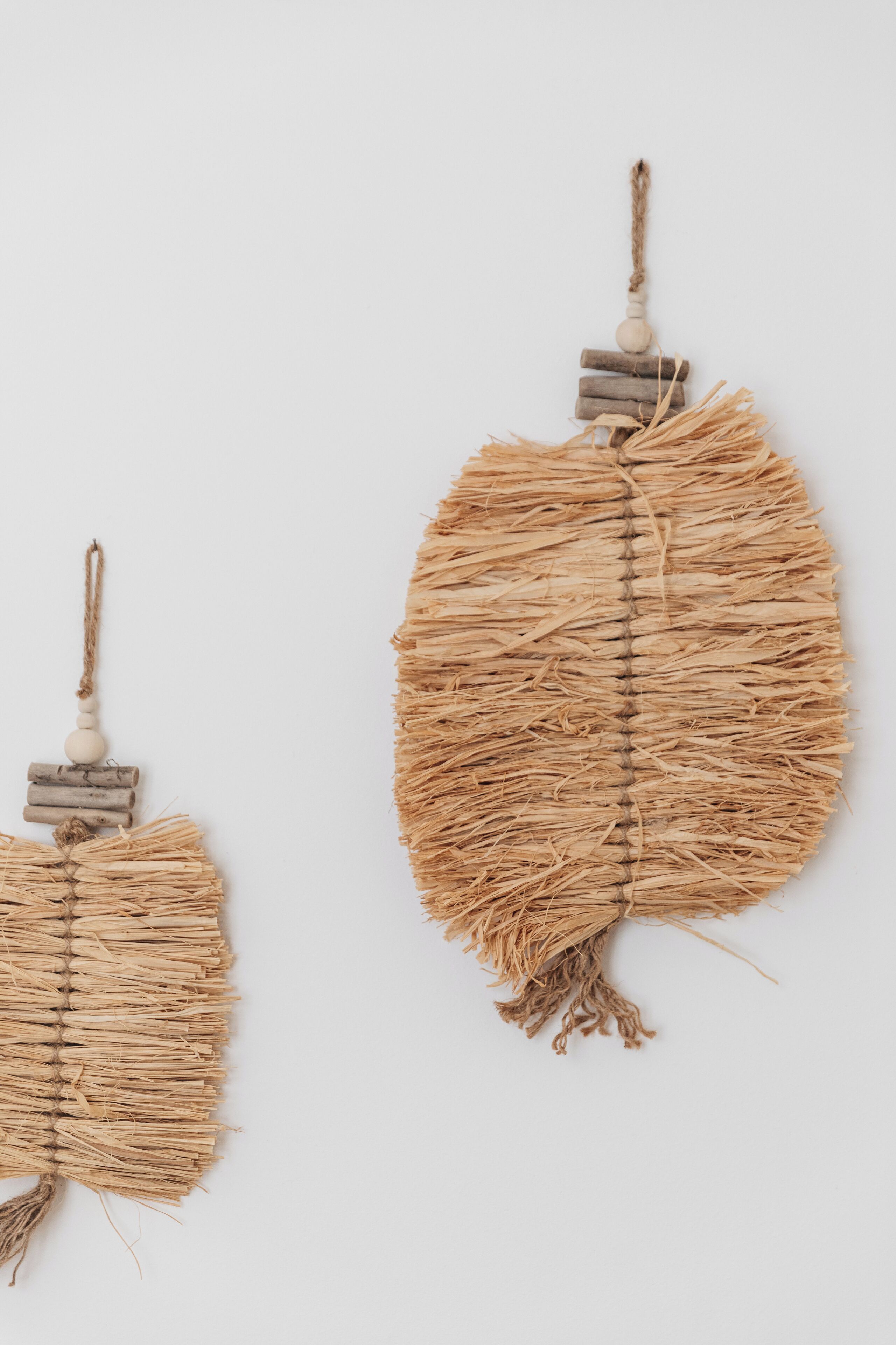 Two wall-mounted decorative items made of natural materials.