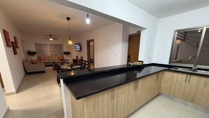 A modern kitchen with a black countertop, wooden cabinets, and a built-in oven.