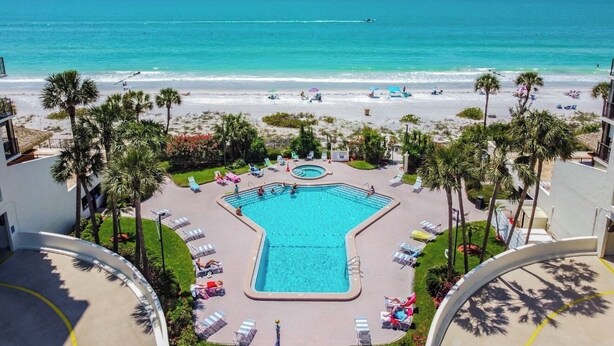 Ein Poolbereich mit Blick auf Strand und Meer.