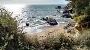 A coastal beach with rocky outcrops, a sandy shore, and a clear sky. - Les Musardises by Interhome (Pornic)