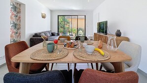 A modern dining area with a wooden table, woven placemats, and a variety of food and drink items. - Les Musardises by Interhome (Pornic)